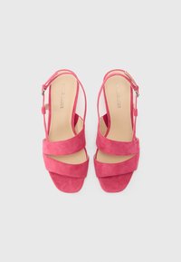 Rosa semskede slingback-sandaler med crossover-remmer, åpen tå-design og justerbar ankelspenne. Glatt indre fôr.