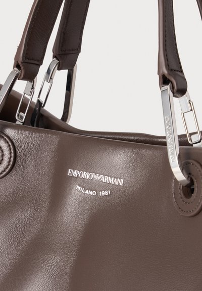 Sac à main en cuir marron Emporio Armani avec poignées en métal argenté et texte du logo ""Milano 1981"" sur la face avant.