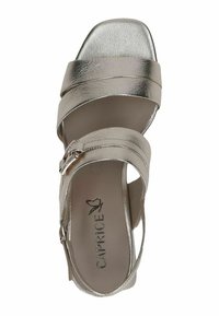 Metalizuoti sidabriniai sandalai su kryžminiais dirželiais, kvadratine nosimi ir žemu kulnu. Yra šoninė sagtis ir tekstūruota pado dalis su prekės ženklo logotipu.