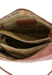 Borsa in pelle marrone aperta per mostrare l'interno in tessuto beige con più scomparti e una tasca con zip, tutti contrassegnati dal testo Pierre Cardin.