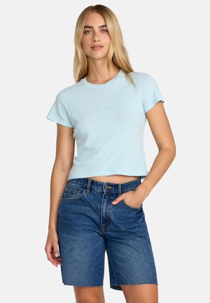 T-shirt corta azzurro chiaro con collo a costine e maniche corte, abbinata a pantaloncini di jeans blu con chiusura a bottoni e tasche.
