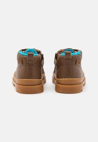 Brown leather ankle boots with a blue fleece lining, side zipper, and rubber soles. Stitched detailing along the sole.