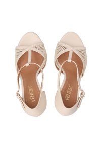 Beige hoge hakken sandalen met een open teen en een kruisgaas ontwerp. Voorzien van een enkelbandje met gespsluiting en een gladde leerachtige afwerking.