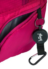 Zaino rosa brillante con una superficie testurizzata, dotato di una tasca con zip nera e un'etichetta rotonda nera con un logo, attaccata da un cappio e una clip.