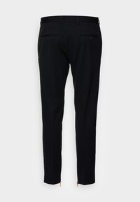 Black tailored pants with a slim fit, made from textured fabric. Features two back pockets with buttons and zippers at the cuffs.