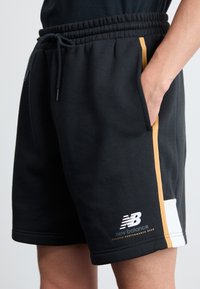 New Balance Pantaloni de trening - black