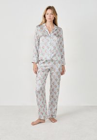 Conjunto de pijama con estampado floral en rayas blancas y verdes, que incluye una camisa con cuello y mangas largas, y pantalones a juego, fabricados en tejido suave.