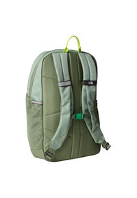 Green padded backpack with adjustable straps, mesh side pockets, a top handle, and contrasting green buckle. Features a logo on the back.