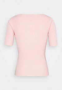 Korte ærmer, ribbet top i lys pink med rund halsudskæring og en tætsiddende silhuet med en glat tekstur.