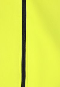 Fluorescerande gul tyg med en slät yta, med en svart dragkedja som g�år vertikalt längs ena sidan.