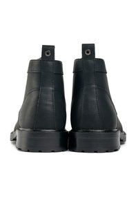 Black leather ankle boots with a smooth finish, structured design, and flat rubber soles. Features a loop pull tab and circular hardware detail.