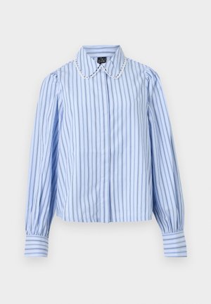 Blouse bleu clair avec des rayures verticales bleu foncé et blanches, manches longues bouffantes, poignets boutonnés, et col arrondi bordé de dentelle festonnée.