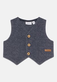 Marineblå vest laget av teksturert stoff, med V-hals, tre treknapper og en liten lærlogo på siden.