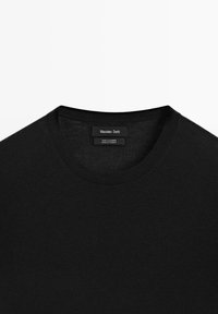 Maglione in cachemire nero con scollatura rotonda, caratterizzato da una texture liscia. L'etichetta include dettagli sul marchio e sui materiali. Design semplice.