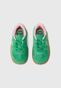 Grønne ruskind sneakers til småbarn med rosa innvendig fôring, grønne snører og gummisåler, vist ovenfra på en hvit bakgrunn.