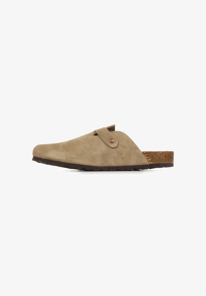 Sabot beige en suède à enfiler avec bride réglable, bout arrondi, semelle intérieure en liège et semelle extérieure en caoutchouc foncé texturé, vu de profil sur fond blanc.