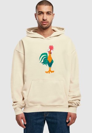 Kremowa bluza z kapturem z dużą grafiką kreskówkowego koguta w kolorach pomarańczowym, zielonym i czerwonym. Posiada kieszeń z przodu oraz luźny krój.
