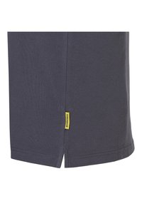 Marineblauwe T-shirt met een gestructureerde stof, zijsplitten bij de zoom en een klein geel label aan de onderrand.