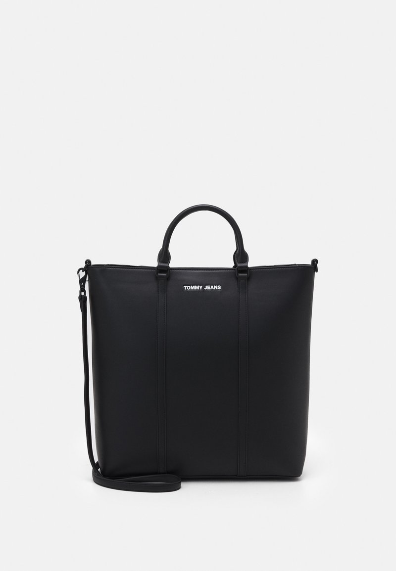 Sac cabas rectangulaire noir avec double poignées, bandoulière amovible et logo "TOMMY JEANS" au centre devant.