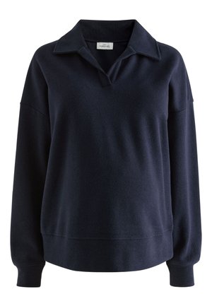 Tumesinise värviga pullover-topp kraega V-kaelusega, pika varrukaga ja soonikkoes mansettidega. Pehme tekstuuriga, lõdvestunud istuvusega ja minimalistliku disainiga.