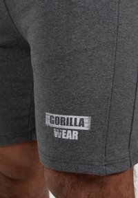 Grijze sportshorts gemaakt van een katoenmix, met een wit "GORILLA WEAR" logo op de onderste zoom en een zachte textuur.