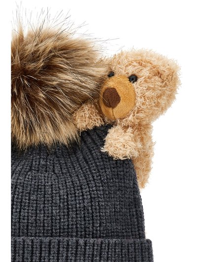 Gorro de punto gris oscuro con un pompón marrón esponjoso y un pequeño oso de peluche como adorno en la parte superior.