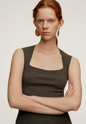 Vestido oscuro ajustado con escote cuadrado y diseño sin mangas. Textura suave y ligero estiramiento. Grandes pendientes ovalados dorados complementan el look.