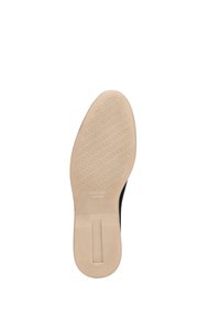 Černá bota s hladkou, texturovanou podrážkou. Podešev je béžová s vzorovaným gripem a nese název značky "WITTCHEN handmade."