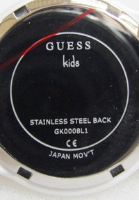 Reloj negro redondo con la inscripción "GUESS kids", borde de acero inoxidable y una línea de acento roja; número de modelo GK0008L1; movimiento de Japón.