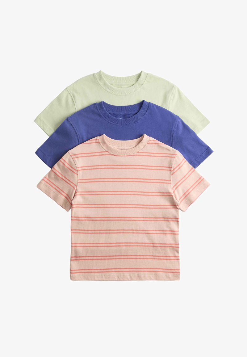 Trois T-shirts en coton à manches courtes pliés empilés, couleurs : rose clair avec des rayures rouges, bleu uni et vert pâle, fond uni.