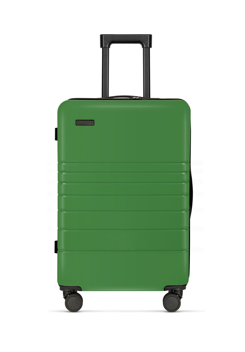 Hartschalenkoffer in grün mit horizontalen Rillen, schwarzem Griff und vier Mobilitätsrädern. Reißverschlussverschluss an der Oberseite. Leichtes Design.