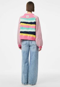 Pull-over coloré avec des rayures rose, verte, jaune et marine, manches texturées et ourlet côtelé. Étiquette de la marque "PIECES" au dos.