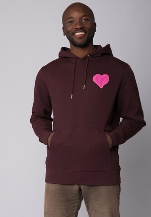 Hoodie bordeaux en tissu doux, avec un design de cœur rose sur le côté gauche de la poitrine et une poche kangourou à l'avant.