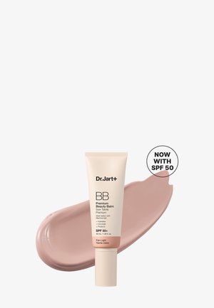 Tube de Dr. Jart+ BB Premium Beauty Balm avec SPF 50, présenté avec un échantillon de la crème teintée claire derrière.