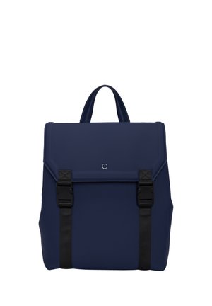 Zaino blu navy con finitura testurizzata, manico superiore, chiusura a patta e due cinturini neri. Design minimalista con un accento circolare.
