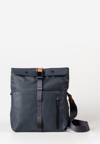 Navy-blaues Täschchen mit Klappenverschluss, verstellbarem Riemen, vorderer Reißverschlusstasche und braunen Akzenten. Hergestellt aus glattem, strapazierfähigem Material.