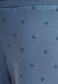 Blauer Strickstoff mit einem dezenten Muster kleiner dunkelblauer Motive. Die Textur ist glatt und leicht dehnbar.