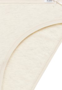Bawełniany string w kolorze off-white, z gładką fakturą, delikatnym przeszyciem i małą kokardką na pasku.