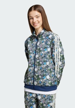 Blommönstrad zip-jacka i marinblått och grönt, med vita ränder på ärmarna, ribbade muddars och en slät textur. Matchande byxor som passar till.