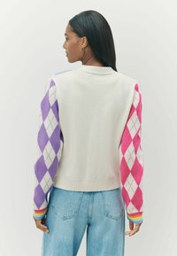 Sweter dzianinowy w kremowym kolorze z rękawami w wielokolorowy wzór argyle w odcieniach fioletu, różu i niebieskiego. Ribbowane wykończenia u dołu i przy mankietach.