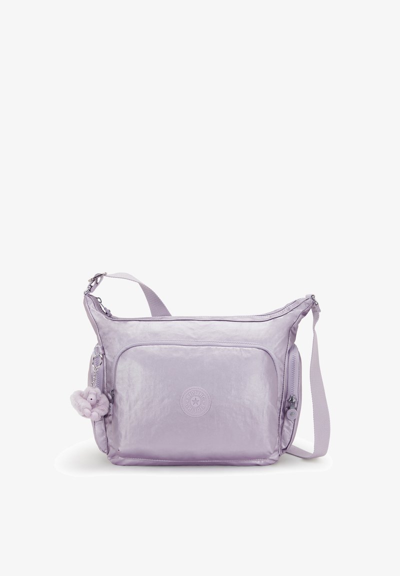 Bolso cruzado de color púrpura claro con bolsillo delantero con cremallera, cremallera lateral, correa ajustable y llavero de un pequeño mono de peluche adjunto.