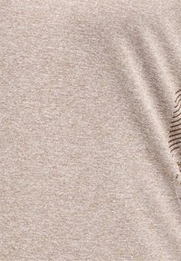 Tela beige clara con una textura sutil, que presenta un patrón ondulado en un lado, suave y ligera, adecuada para superponer o para uso informal.