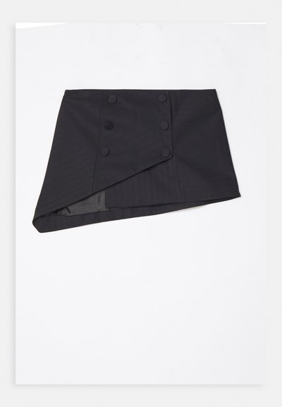 Gonna nera avvolgente realizzata in tessuto testurizzato, con orlo diagonale, bottoni laterali e una fodera interna liscia.