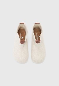 Witte wollen pantoffels met bruin leren accenten, ronde neus en treklabel aan de hiel; zachte, gestructureerde oppervlakte met een naadloos ontwerp.