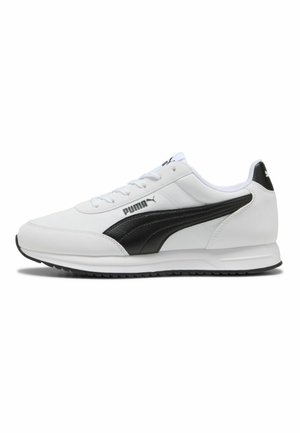 Zapatilla blanca Puma con franja de logotipo negra en el lateral, cierre con cordones y suela negra texturizada.