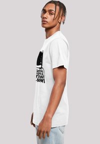 White cotton T-shirt featuring a black graphic design on the front, displaying stylized text and shapes. Short sleeves, standard fit.