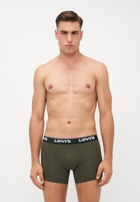 Boxer brev verde in cotone con elastico nero che presenta il logo bianco "Levi's". Progettati per una vestibilità aderente, con cuciture minime e texture liscia.