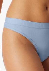 Ljusblå tangaunderkläder med en slät yta och en mjuk midjeband prytt med varumärket "ELLE."