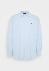 Camisa de botones de manga larga azul claro con un pequeño patrón de puntos y un pequeño logo en el lado izquierdo del pecho.
