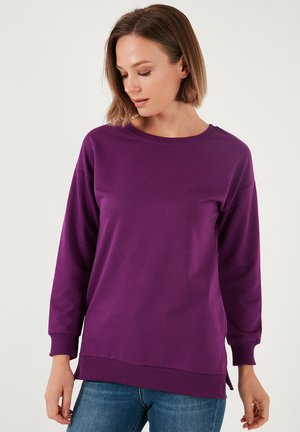 Felpa lunga viola con maniche lunghe, scollo rotondo, polsini a costine e spacchi laterali. Realizzata in tessuto morbido, adatta per un abbigliamento casual.